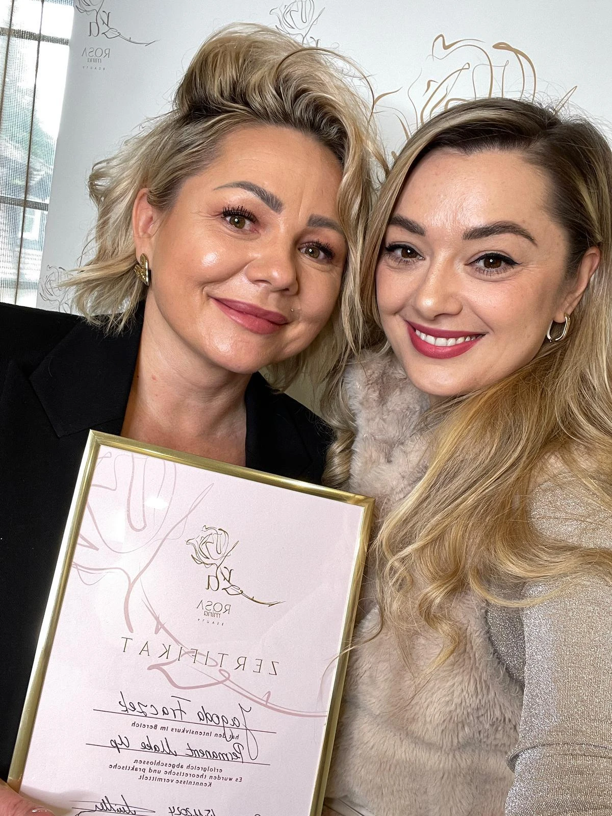 Zwei Frauen mit einem gerahmten Zertifikat in der Academy.