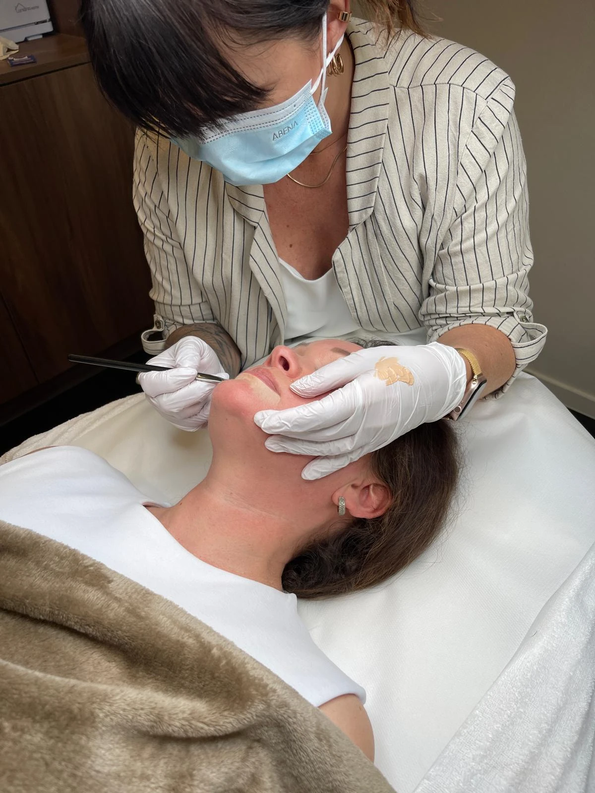Eine Teilnehmerin arbeitet mit Handschuhen und PMU-Gerät am liegenden Modell.