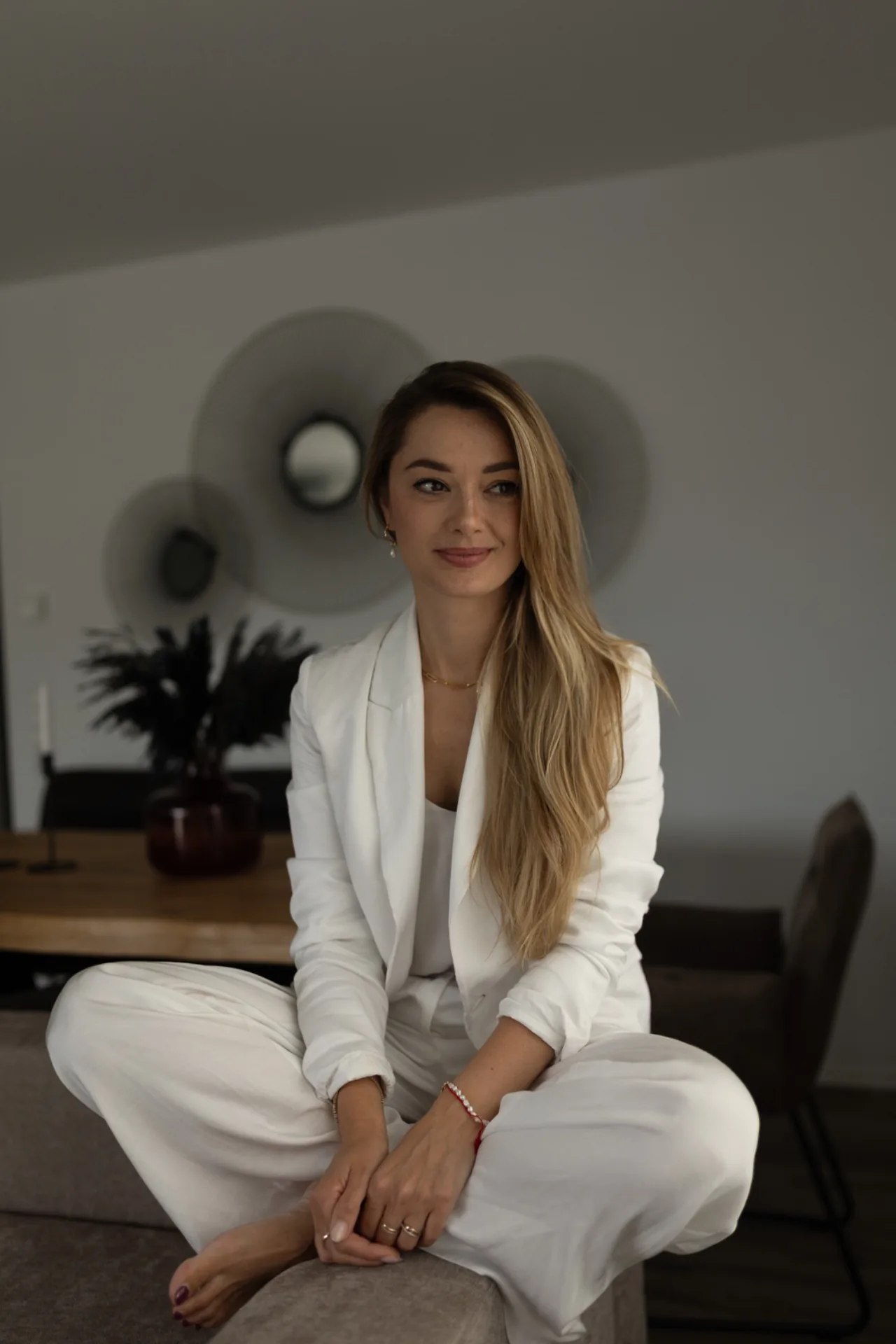 Natalie im weißen Anzug, sitzend im Studio von Rosamina Beauty