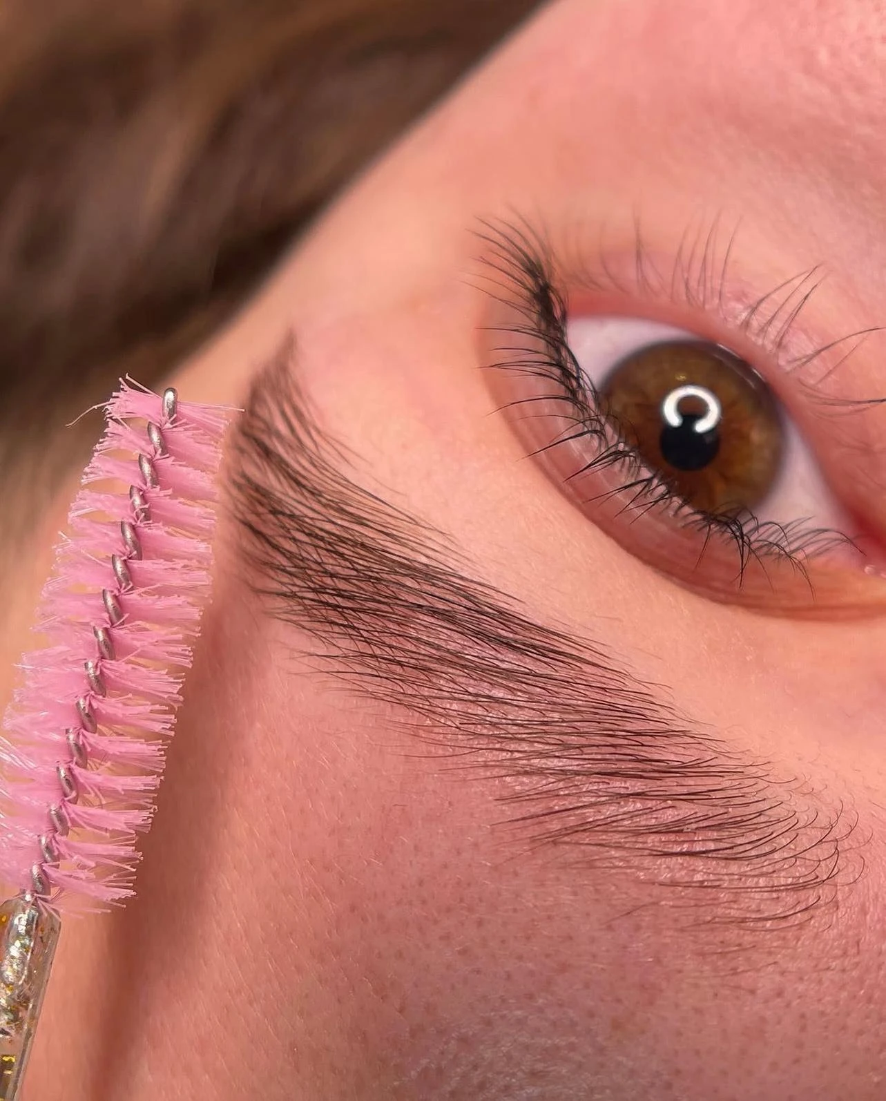Detailaufnahme von gelifteten Wimpern und geformten Brauen.